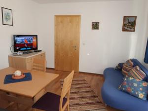Una sala de estar con una mesa y un sofá azul. en Apartment Frisch by Interhome, en Imst