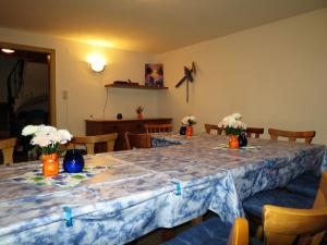 ein Esszimmer mit einem Tisch mit Blumen in Vasen darauf in der Unterkunft Apartment Max - HBN160 by Interhome in Winkle