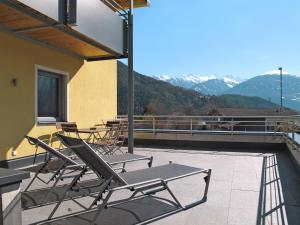 um pátio com cadeiras e mesas numa varanda com montanhas em Apartment Edith - IST100 by Interhome em Imst