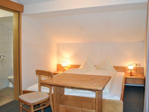 a bedroom with a bed and a table and a toilet at Holiday Home Gaugg by Interhome in Sankt Leonhard im Pitztal