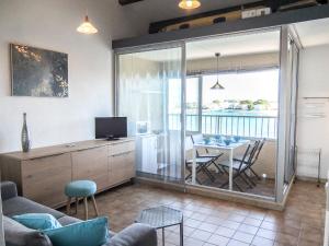 un soggiorno con cucina e una sala da pranzo con tavolo di Apartment Marina Village-2 by Interhome a Saint-Cyprien-Plage