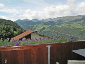 a fence with purple flowers on top of a mountain at Apartment Alpenherz - PTZ430 by Interhome in Fendels