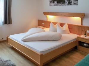 sypialnia z łóżkiem z białymi prześcieradłami i poduszkami w obiekcie Apartment Walch-2 by Interhome w mieście Fendels