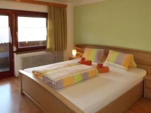 sypialnia z dużym łóżkiem i kolorowymi poduszkami w obiekcie Apartment Zechner-3 by Interhome w mieście Tobadill