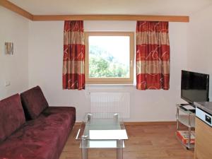 ein Wohnzimmer mit einem Sofa und einem Fenster in der Unterkunft Apartment Alpenherz - PTZ431 by Interhome in Fendels