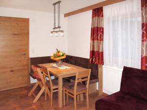 einen Esstisch und Stühle in einem Zimmer in der Unterkunft Apartment Alpenherz - PTZ431 by Interhome in Fendels