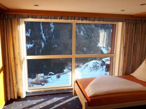 カップルにあるApartment Selina - KPL395 by Interhomeの雪に覆われた山を望む窓付きのベッドルーム