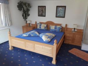 a bedroom with a wooden bed with blue sheets and pillows at Apartment Selina by Interhome in Kappl