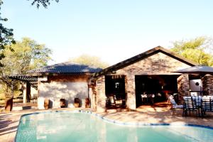 a swimming pool in front of a house at Barnstormers Rest in Malelane
