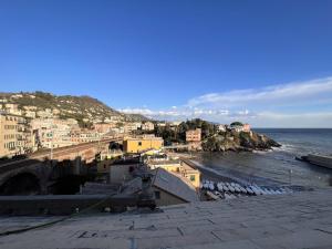 vista su una città e sull'oceano con edifici di Mansarda Sul Porticciolo 1b/1b 50mq with seaview a Genova