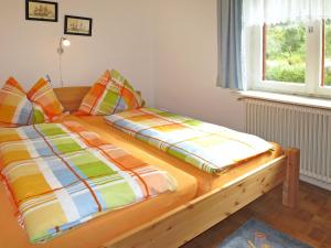 a bedroom with a bed with colorful sheets and a window at Holiday Home Lux by Interhome in Öblarn