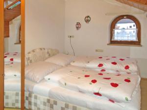 two beds in a room with roses on the sheets at Apartment Hödl - TCH180 by Interhome in Schruns
