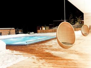 カルス・アム・グロースグロックナーにあるChalet Gradonna Mountain Resort - KAX101 by Interhomeのスイミングプール(椅子2脚、ブランコ付)