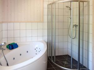 a bathroom with a tub and a shower at Holiday Home Holiday Vital Resort - GBE122 by Interhome in Großenbrode