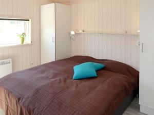 a bedroom with a bed with a blue pillow on it at Holiday Home Holiday Vital Resort - GBE122 by Interhome in Großenbrode