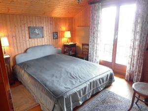 ヴェルコランにあるChalet Gillioz by Interhomeの木製の部屋に大型ベッドが備わるベッドルーム1室が備わります。
