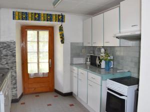 a kitchen with white cabinets and a blue counter top at Holiday Home Villa Roduit by Interhome in Le Châble