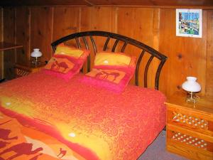 a bedroom with a large red bed with two pillows at Holiday Home Villa Roduit by Interhome in Le Châble