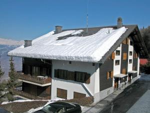 ein Haus mit einem schneebedeckten Dach darüber in der Unterkunft Apartment Bellevue L by Interhome in Veysonnaz