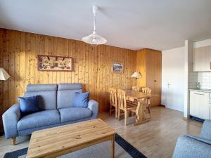 ein Wohnzimmer mit einem Sofa und einem Tisch in der Unterkunft Apartment Bellevue L by Interhome in Veysonnaz