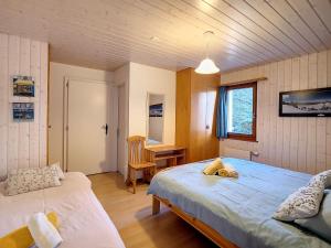 a bedroom with two beds and a desk in it at Apartment Bellevue L by Interhome in Veysonnaz