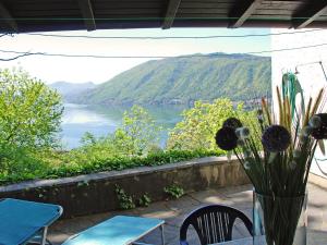 a vase of flowers on a table with a view of a lake at Holiday Home Christa by Interhome in Bissone