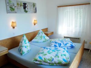 a bed in a room with two pillows on it at Holiday Home Christa by Interhome in Bissone