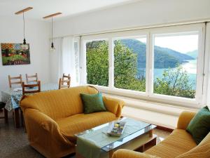 a living room with two couches and a large window at Holiday Home Christa by Interhome in Bissone