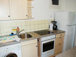 a kitchen with a sink and a white refrigerator at Holiday Home Christa by Interhome in Bissone +12 photos