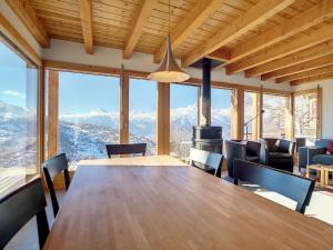 comedor con mesa, sillas y montañas en Chalet au Bisse by Interhome en Veysonnaz