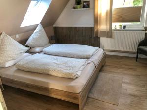 ein Bett mit zwei Kissen auf einem Zimmer in der Unterkunft Apartment Hannelore-2 by Interhome in Bübbens