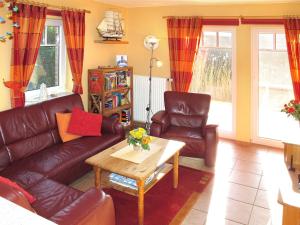 uma sala de estar com um sofá, cadeiras e uma mesa em Holiday Home Korsar II by Interhome em Burhave