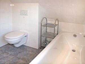 a bathroom with a toilet and a bath tub at Holiday Home Korsar II by Interhome in Burhave