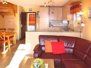 uma sala de estar com um sofá de couro e uma cozinha em Holiday Home Korsar II by Interhome em Burhave