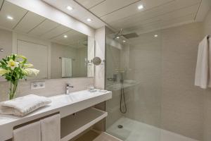 ein Bad mit einem Waschbecken und einer Dusche mit einem Spiegel in der Unterkunft Hotel Illa d'Or & Club Apts 4* Sup in Port de Pollença