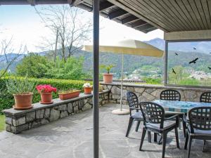 patio con tavolo, sedie e ombrellone di Holiday Home Cityview Lugano - Casa Carlo by Interhome a Cadro