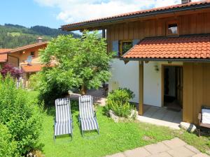 two chairs in the yard of a house at Holiday Home Chalet Walchsee by Interhome in Sachrang