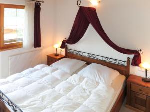 a bedroom with a large bed with white sheets at Holiday Home Chalet Walchsee by Interhome in Sachrang +15 photos
