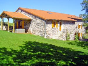 una casa in pietra con il tetto arancione su un prato verde di Holiday Home ferme by Interhome a Agizoux Altre 15 foto