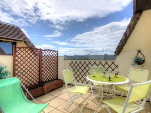 un patio con mesa, sillas y una valla en Apartment Le Garden Fleuri by Interhome, en Blonville-sur-Mer
