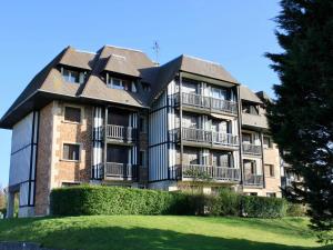 a large apartment building with a lawn in front of it at Apartment Le Garden Fleuri by Interhome in Blonville-sur-Mer