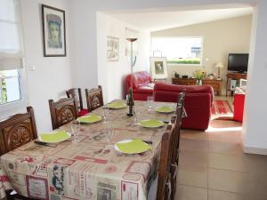 Plobannalec-LesconilにあるHoliday Home Sables Blancs by Interhomeのダイニングルーム(テーブル、赤いソファ付)