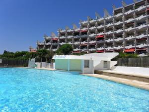 a large swimming pool in front of a building at Apartment Du Soleil-2 by Interhome in La Grande Motte