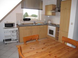 une cuisine avec des placards en bois et une table en bois dans l'établissement Apartment Gartenstraße-2 by Interhome, à Karlshagen