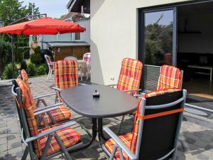 einen Tisch mit Stühlen und einem Sonnenschirm auf einer Terrasse in der Unterkunft Holiday Home Johannika by Interhome in Godern