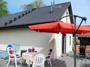 eine Terrasse mit einem Tisch, Stühlen und einem Sonnenschirm in der Unterkunft Holiday Home Johannika by Interhome in Godern