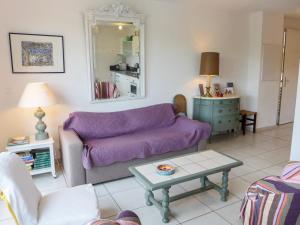 een woonkamer met een paarse bank en een tafel bij Apartment Les Demeures de Brindos by Interhome in Anglet