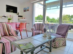 ein Wohnzimmer mit Stühlen und einem Couchtisch in der Unterkunft Apartment Les Demeures de Brindos by Interhome in Anglet