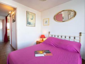 ル・グロー・デュ・ロワにあるHoliday Home Port Nautile-1 by Interhomeのピンクベッド1台(鏡付)が備わるベッドルーム1室を提供しています。