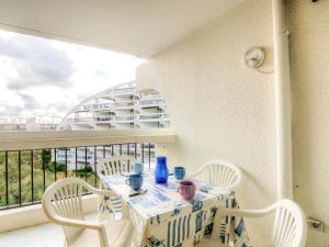 a table and chairs on a balcony with a view of a building at Studio Ulysse Plage-12 by Interhome in La Grande-Motte
